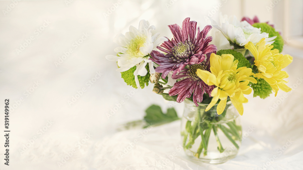 colorful bouquet of chrysanthemums on a light background green pink and yellow colors macro selective focus