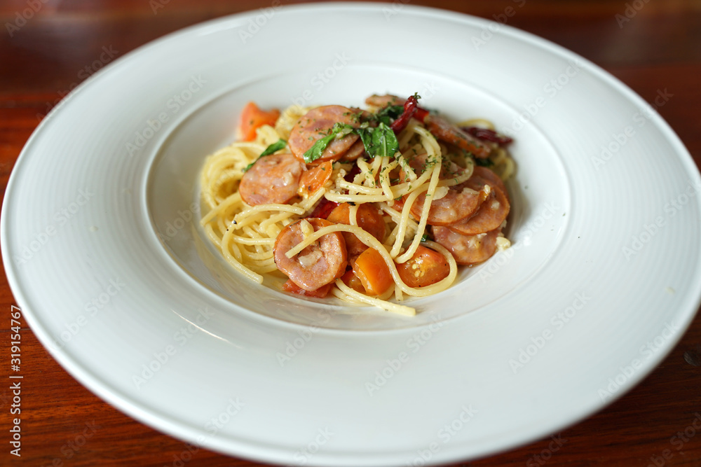 Italian sausage spaghetti sauce serving in the white bowl on timber table