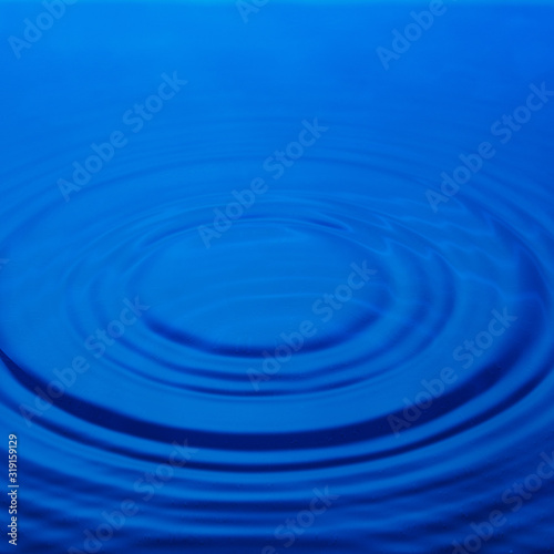 Circles on the water, blue background. Abstraction.