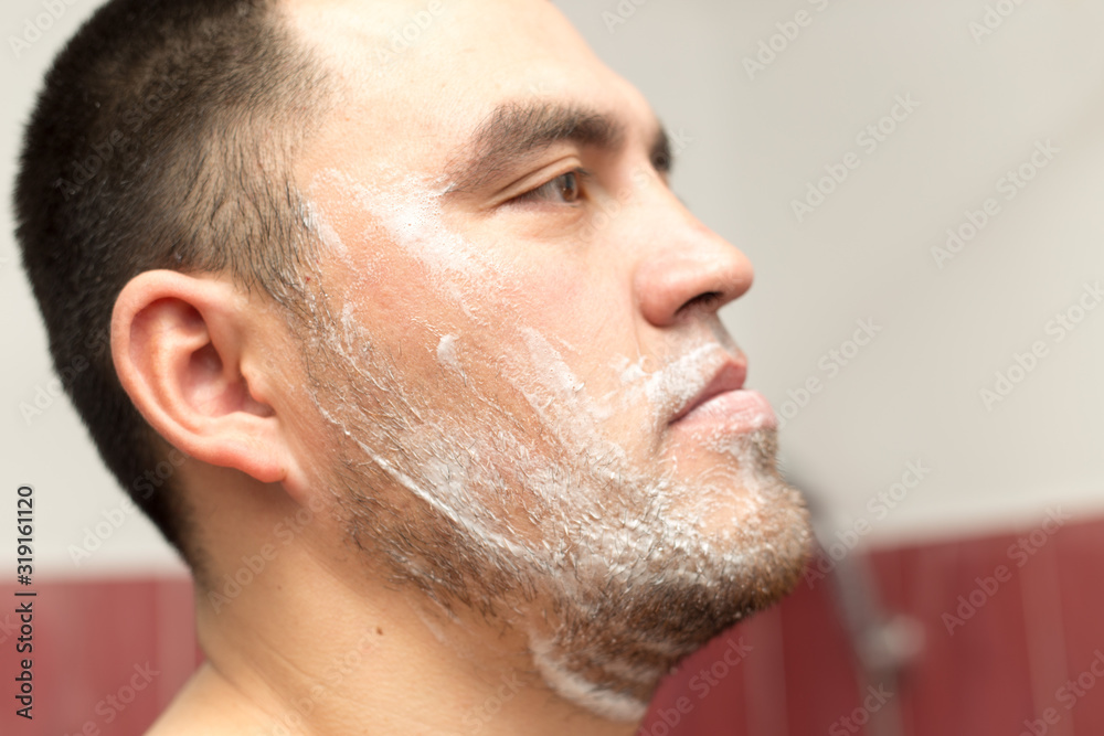 Obraz premium man shaves his beard in a bath