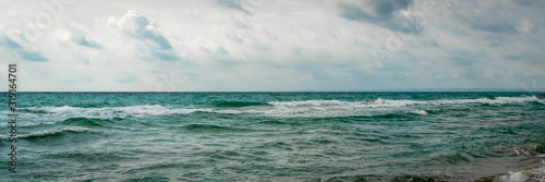 Panorama of big stormy waves on the coast. Dramatic sky background. Skyline, horizon. Amazing view of grey rainy clouds in the ocean. Header. © GenоМ.