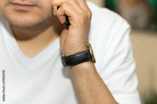 a man in the office talking on the phone at the hands of the wristwatch