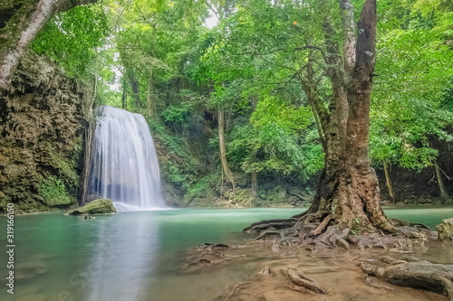 Beautiful silky water flowing on cliff rock around with blue-green water and green forest background  Erawan waterfalls 3th step  Kanchanaburi  west of Thailand.