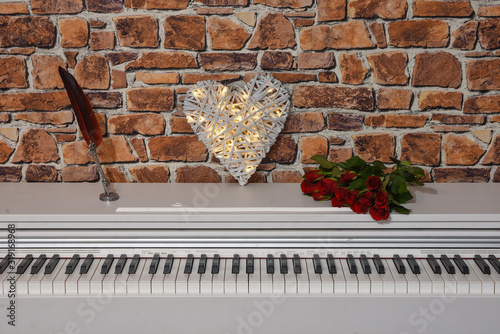 A piano, a heart, a bouquet of roses and a writing pen