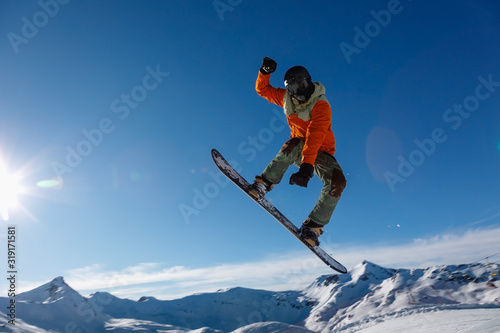 Male Snowboarder Catches Big Air on a Bright Sunny Day