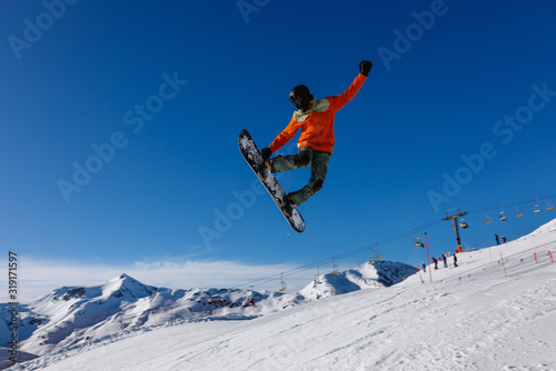 Snowboarder does the jumping trick. Livigno, Italy