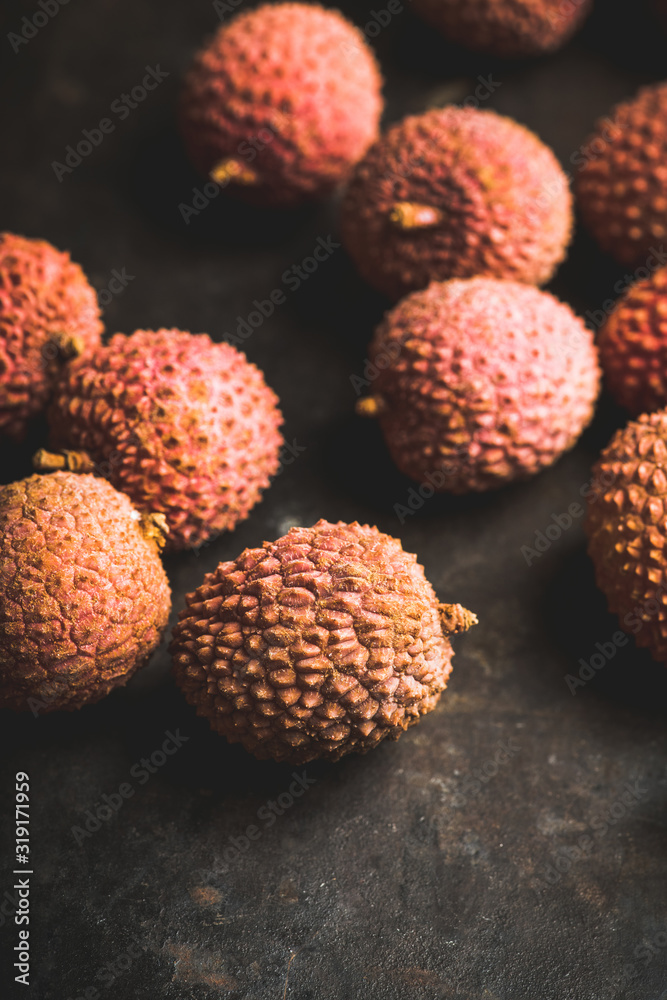 Red ripe lychees on the rustic background. Selective focus. Shallow depth of field. Red ripe lychees on the rustic background. Selective focus. Shallow depth of field.