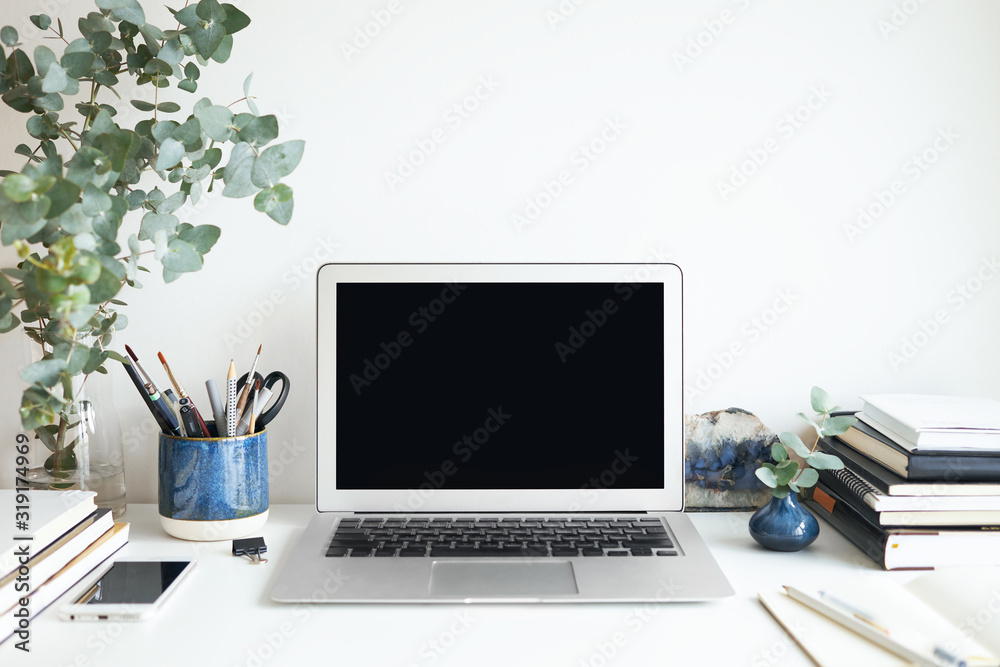 Fototapeta premium Stylish work space with laptop with blank copy space display for your design, template, information or text. Modern lifestyle, distant job, occupation and electronic gadgets concept. Isolated image