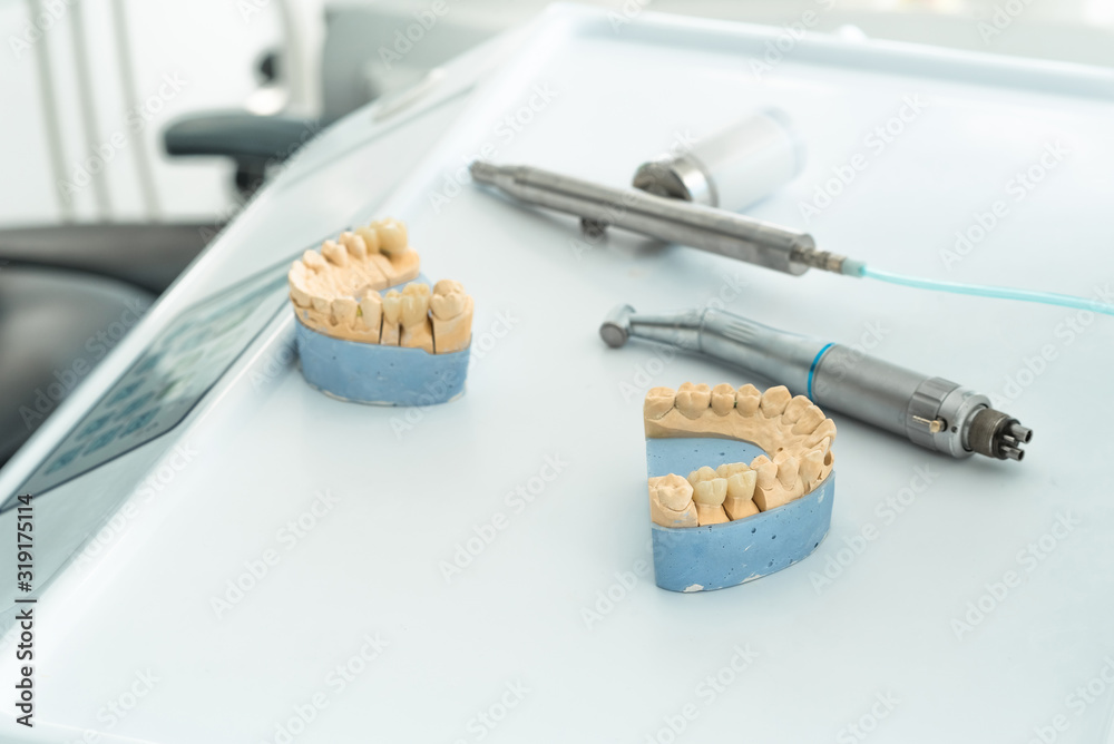 Artificial chew with made tooth crowns is standing on the table in the dental laboratory. Technical and professional equipment.
