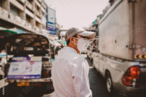 Man wearing a mask to protect against viruses and dust on the street,corona and pm2.5 concept. © Jantanee