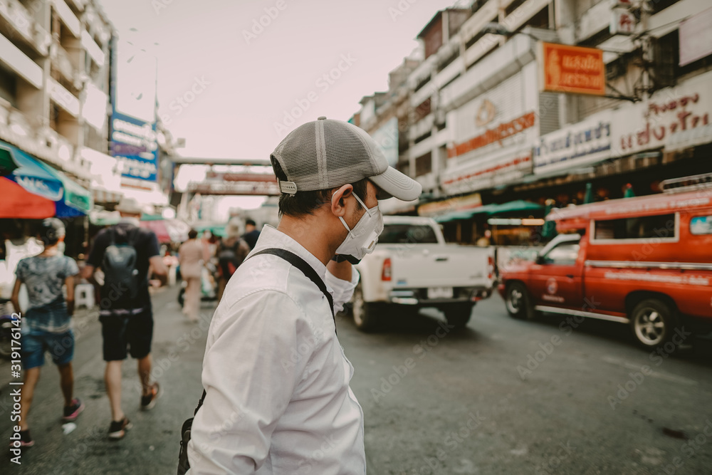Man wearing a mask to protect against viruses and dust on the street,corona and pm2.5 concept. Man wearing a mask to protect against viruses and dust on the street,corona and pm2.5 concept.
