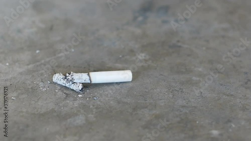 Cigarette butt on concrete floor. Footage of health care concept.