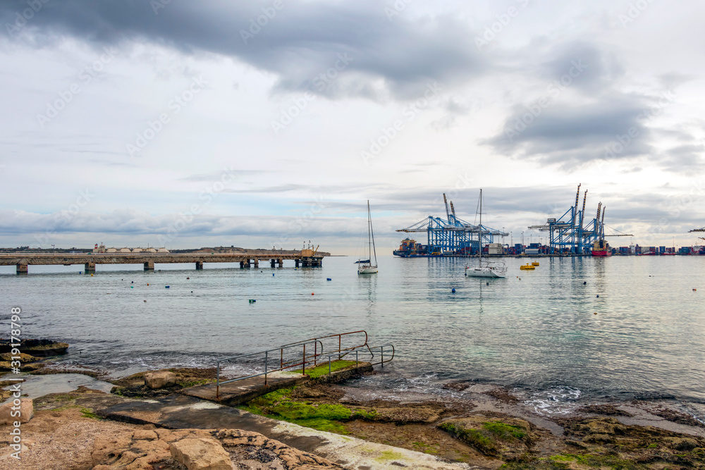 Malta Freeport Terminals, an international port in the Mediterranean sea region, harbor with cranes, ships and cargo, Marsaxlokk, Europe