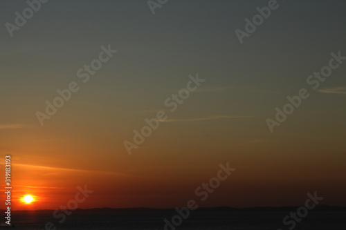 Serene twilight with orange and blue sky with thin horizon line
