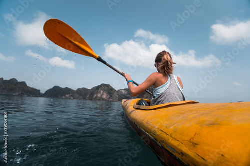 Woman paddles kayak in the Ha Long Bay in Vietnam