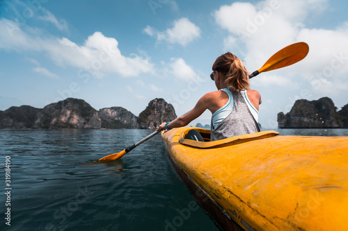 Woman paddles kayak in the Ha Long Bay in Vietnam