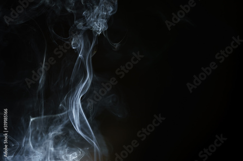 Abstract smoke from incense and light in a black background