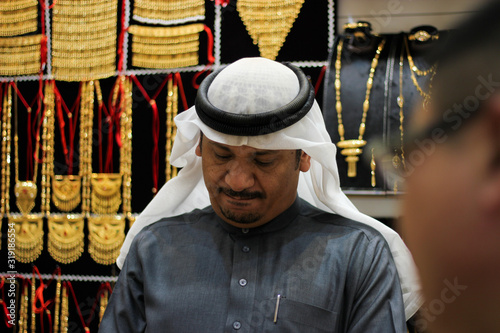 Arab jeweler haggling with asian customers. He s trying to convince them for a fair price