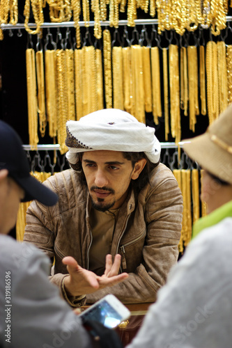 Arab jeweler haggling with asian customers. He's trying to convince them for a fair price