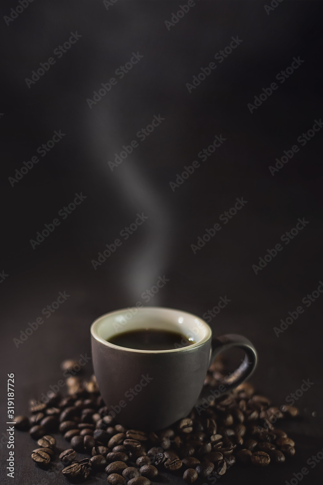  cup of coffee and coffee grains with smoke on a dark background.