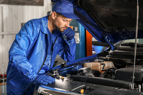 Male mechanic working in ca...