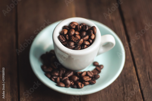 cup with coffee grains on a wooden background.