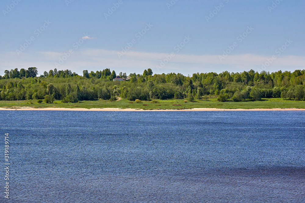 Summer landscape of a river bank, with green forest and village buildings Summer landscape of a river bank, with green forest and village buildings