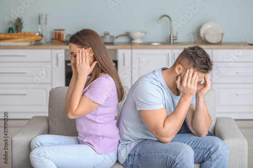 Upset young couple sitting ...