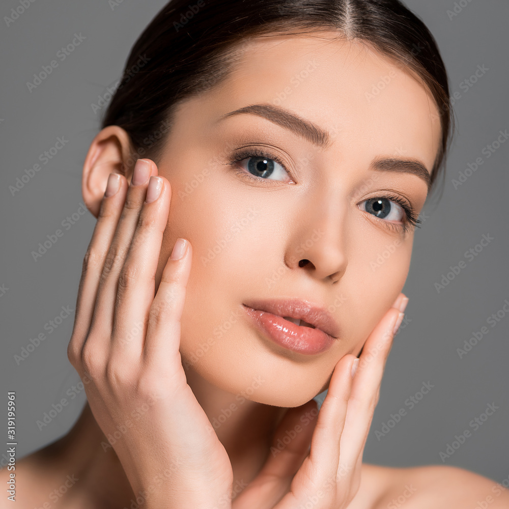 portrait of beautiful tender woman with clean skin, isolated on grey