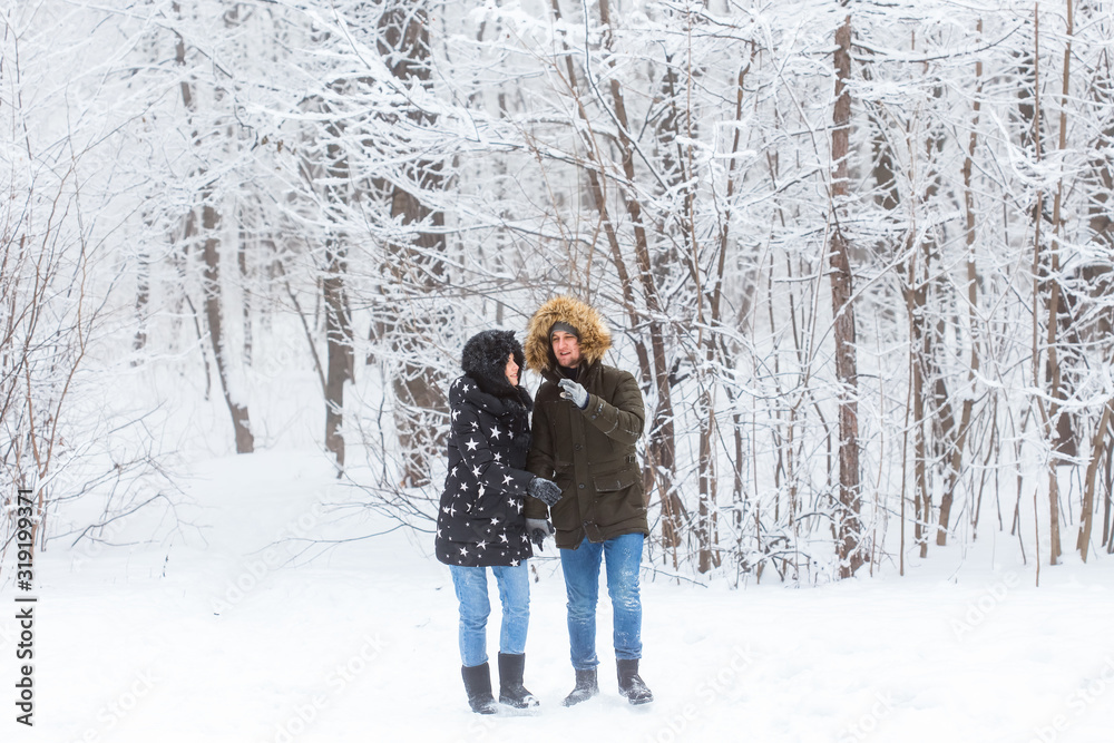 Happy loving couple having fun outdoors in snow park. Winter vacation