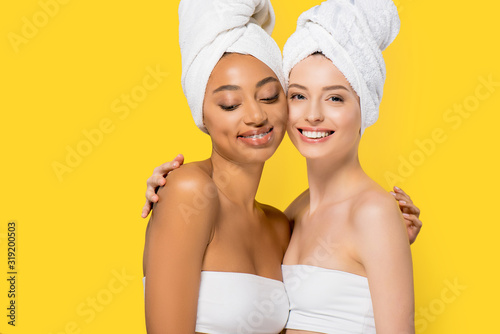 happy multicultural girls with towels on heads, isolated on yellow