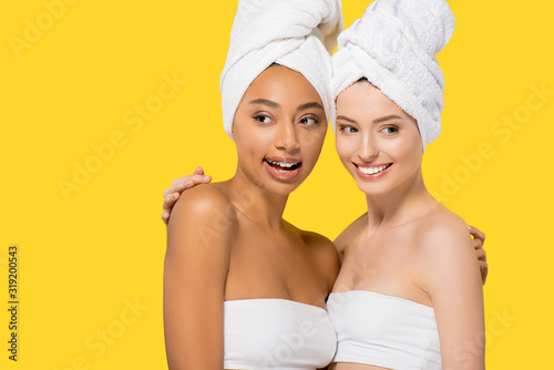 smiling multicultural girls with towels on heads  isolated on yellow