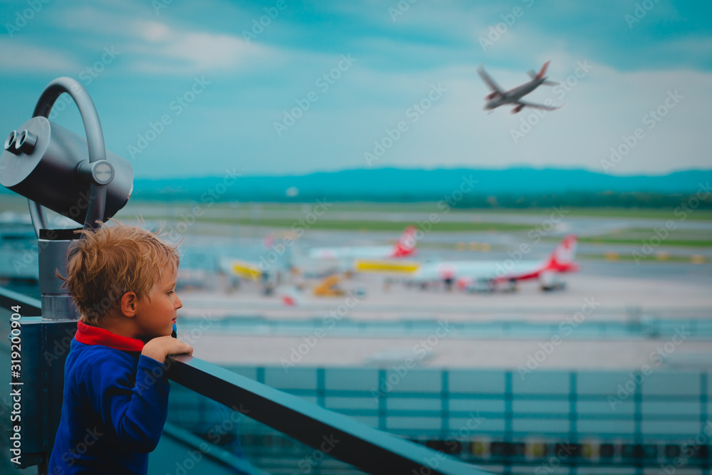cute little boy looking at planes in the airport