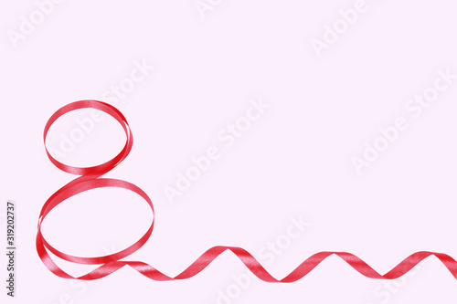 March 8 ribbon shape on a pink background. Tinted trendy classic red. Concept of International Women's mother's Day. Empty space for text.