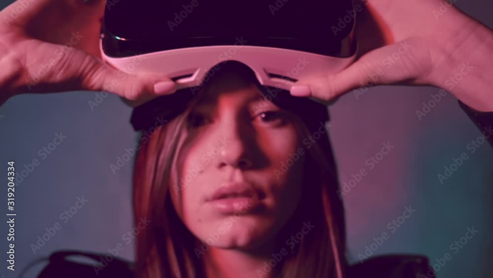 Young beautiful woman in a leather jacket putting virtual reality head set on her eyes