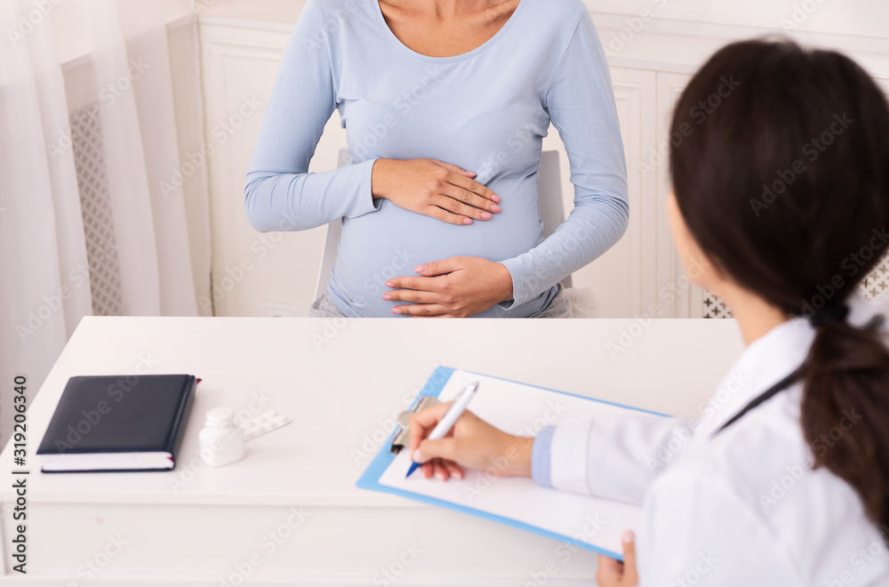 Fototapeta premium Unrecognizable Doctor Talking With Patient During Pregnancy Check-Up Visit Indoor