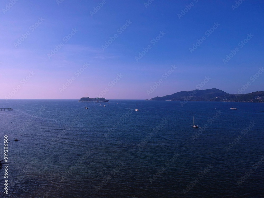 Panoramic View of Patong Beach buildings boats parasailing jetski people on the beach and beautiful blue skies long tail boats Panoramic View of Patong Beach buildings boats parasailing jetski people on the beach and beautiful blue skies long tail boats