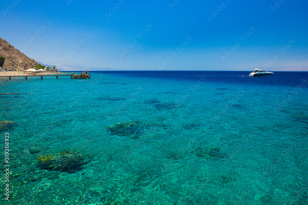 Red sea landscape summer time Israeli scenic view coral reefs beach relaxation people on a pier and yacht on water surface in sunny weather bright day beautiful destination for vacation season
