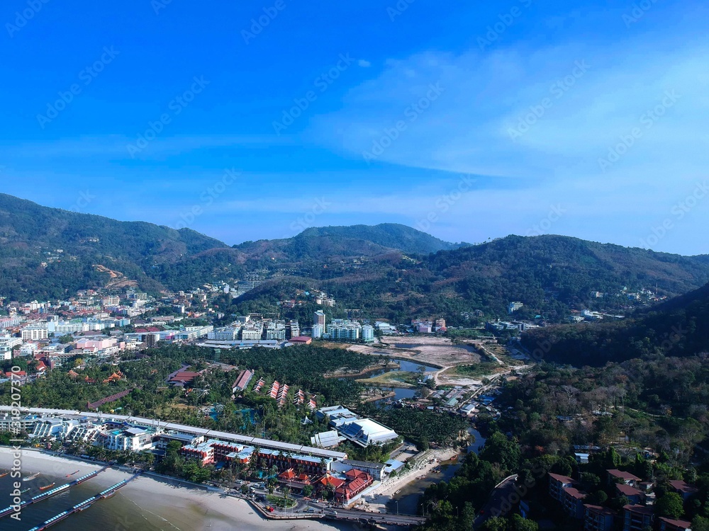 Fototapeta premium Panoramic View of Patong Beach buildings boats parasailing jetski people on the beach and beautiful blue skies long tail boats