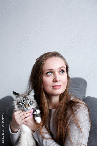 Close-up portrait of young confident attractive woman with her cute cat  female with long hair