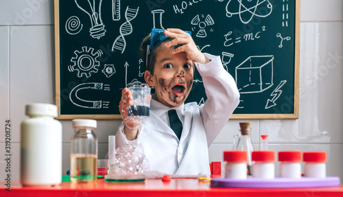 Funny boy dressed as chemist with dirty face after a failed experiment photo