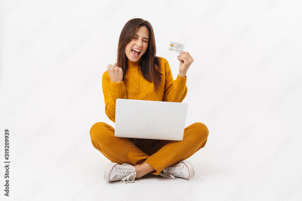 Image of brunette adult woman holding laptop computer and credit card Image of brunette adult woman holding laptop computer and credit card