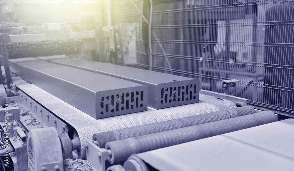 Brick production. New bricks on a conveyor belt at a brick factory. Text space Brick production. New bricks on a conveyor belt at a brick factory. Text space