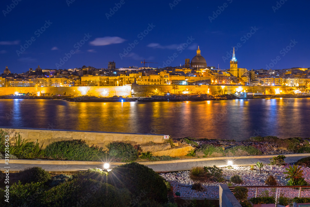Rocky coastline of Malta and the architecture of Valletta city at night