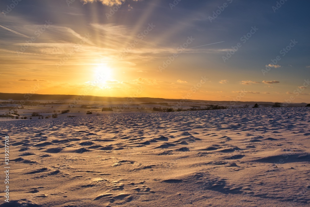 Sonnenstrahlen in der verschneiten Winterlandschaft