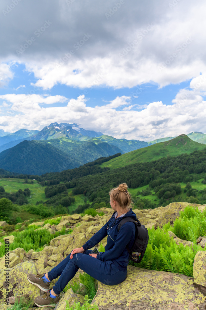 a tourist is walking along a mountain path. panorama of the Alpine mountains . mountain tourism. a trail for a walking route. Caucasian mountains. summer landscape with mountains.