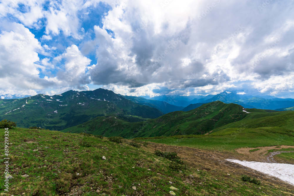 panorama of the Alpine mountains and high ridges. Caucasian mountains. summer landscape with mountains, flowers, blue sky, fresh air