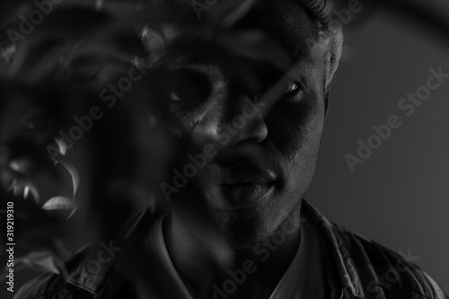 Closeup portrait of a black american man with big lips in black and white light in smoke