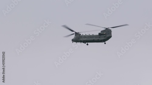 Chinook military helicopter flying in the sky in the daytime. 