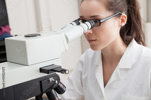Foto Laboratory assistant uses a polarizing microscope in a microbiological laborator